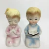 Vintage ceramic salt and pepper shakers with praying children in pastel clothing