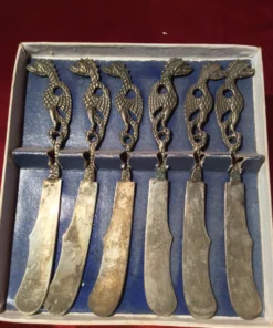 Dragon handle detail – close-up of sculpted knife handles in box