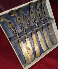 Side view of antique dragon knife set inside original box with blue insert