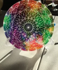 Rainbow chakra charger plate displayed on black background stand