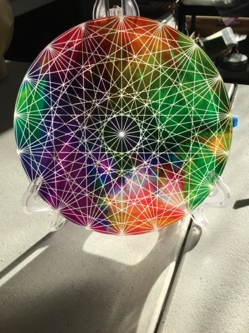 Rainbow chakra charger plate displayed on black background stand