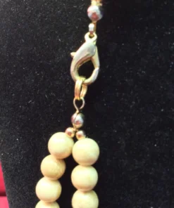 Close-up of gold lobster clasp with bead connectors.