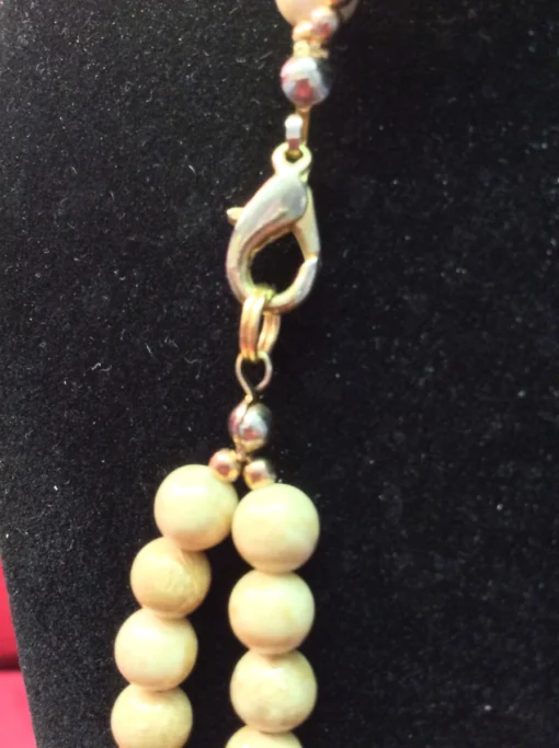 Close-up of gold lobster clasp with bead connectors.