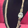 Vintage beaded necklace with double strands and shell inlay pendant on display bust.