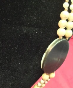 Side view of the pendant revealing shell inlay depth and curved finish.