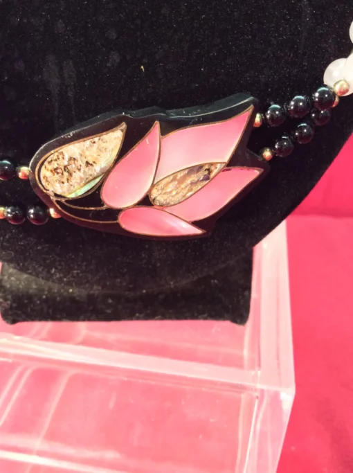Close-up of pink lotus pendant with abalone shell inlay