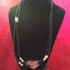 Full necklace on black display with pink backdrop