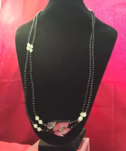 Full necklace on black display with pink backdrop