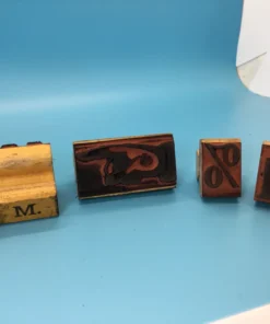 Several wooden rubber stamps laid out showing letter and symbol faces
