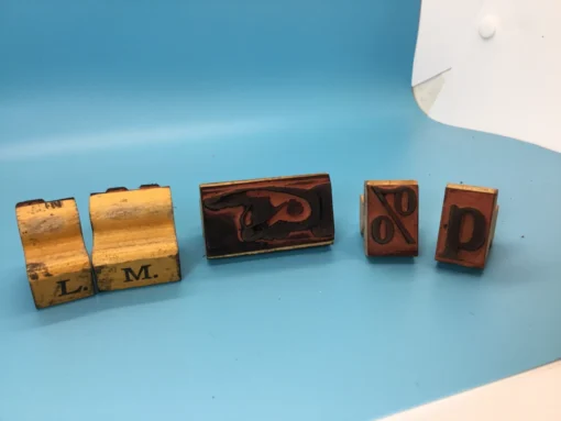 Several wooden rubber stamps laid out showing letter and symbol faces