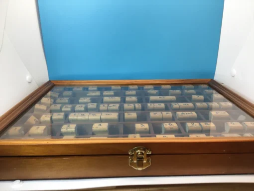 Front-facing view of entire wooden stamp case with ruler across bottom
