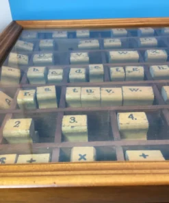 Organized rubber stamps arranged alphabetically in glass-topped wood box