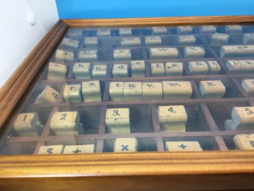 Organized rubber stamps arranged alphabetically in glass-topped wood box