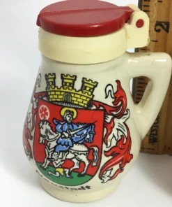 Close-up of vintage red-lidded Neustadt salt shaker showing crest