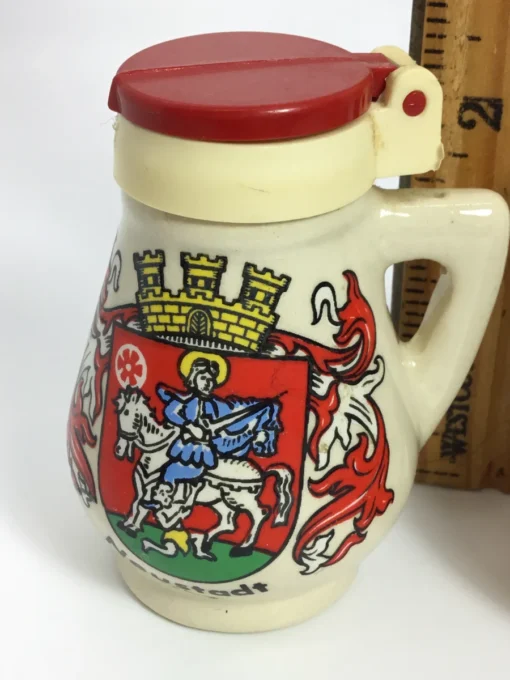 Close-up of vintage red-lidded Neustadt salt shaker showing crest