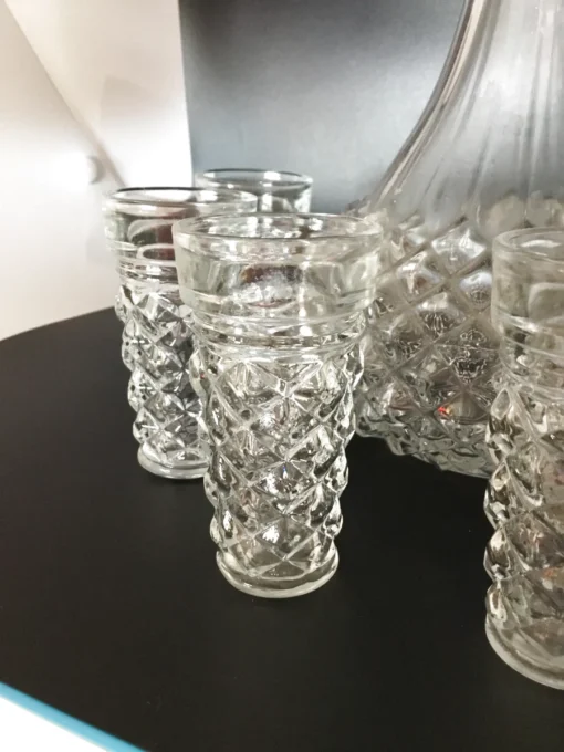 Close-up of matching glasses from vintage crystal-style decanter set